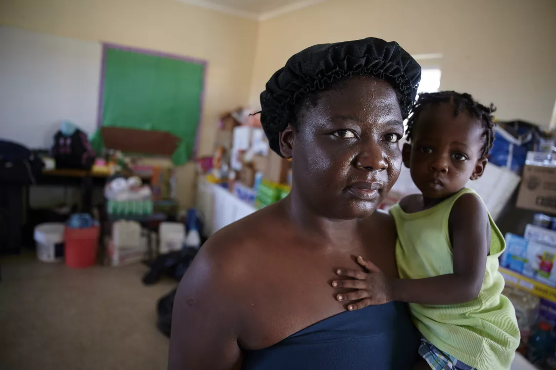 A woman holds a child at a shelter