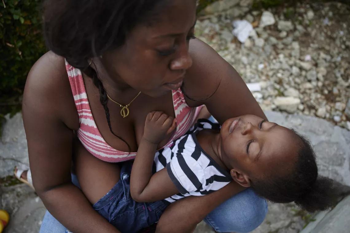 A woman holds a child at a temporary shelter