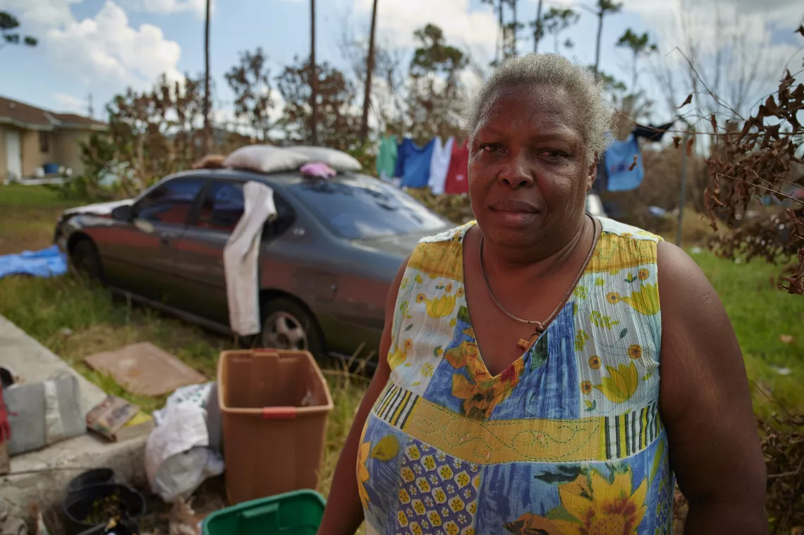 A owemab cleans up her yard outside her house after the hurricane.