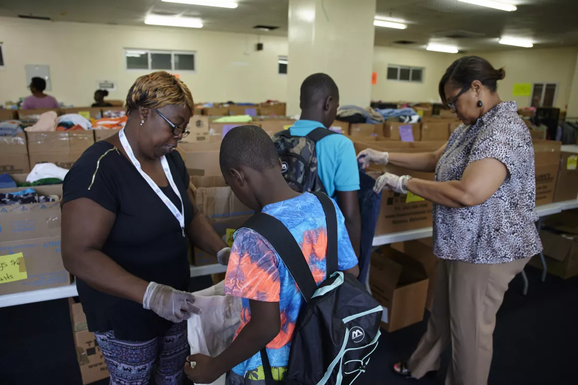 Two boys collect clothing at a shelter.