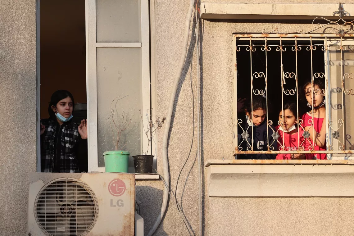 Gaza. Children look out of the window of their house.