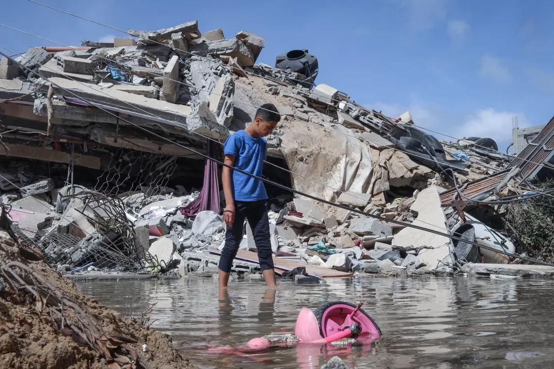 Gaza. A boy walks around the remains of his home.