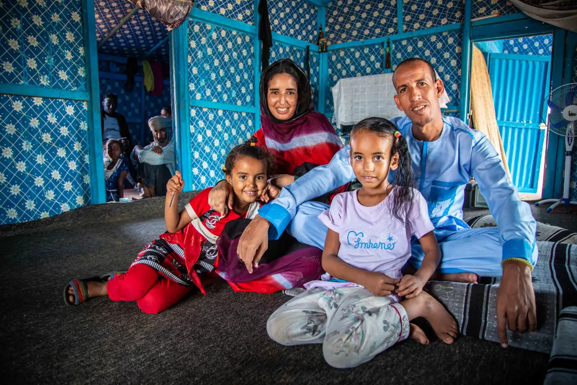 Vaccine ambassador Mariam sits beside her family at the M'Berra refugee camp in Mauritania