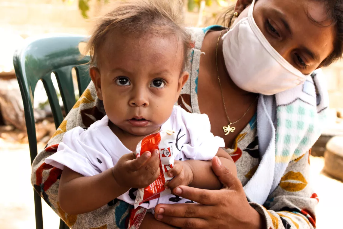 Venezuela. A boy eats a ready-to-use therapeutic food during a nutrition screening day in Zulia.