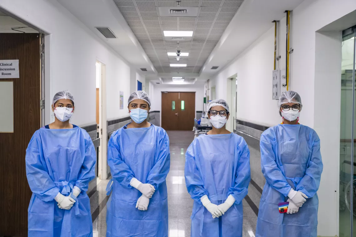 Healthcare workers in India stand outside a ward in a hospital where they're treating COVID-19 patients.