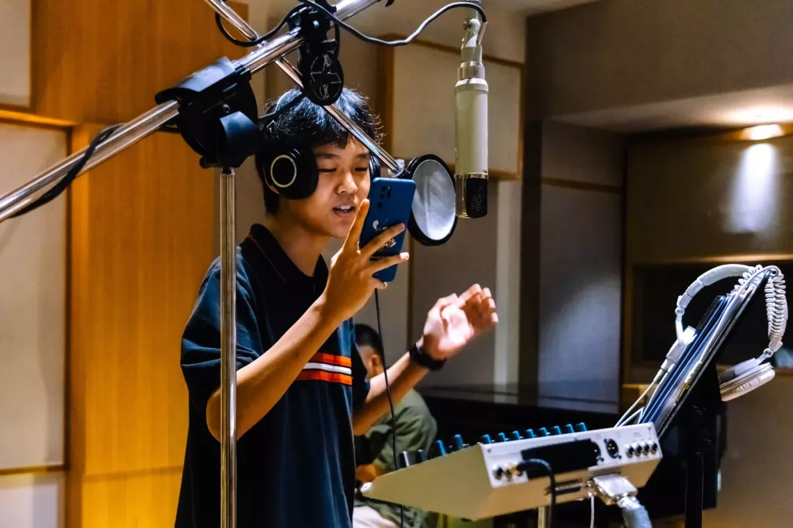 Young person singing a song in studio