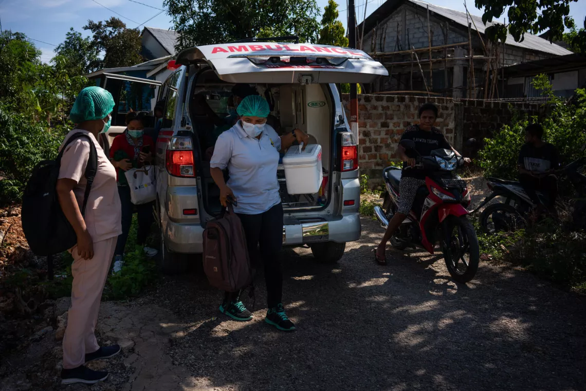 Healthcare workers from a clinic in Kupang, Indonesia, run a field vaccination clinic in a local community.