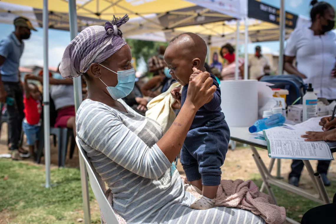 Mother Neliswa Mnana holds her son, 6-month-old Phatu, at a pop-up vaccination site run by the Zwakala campaign.  