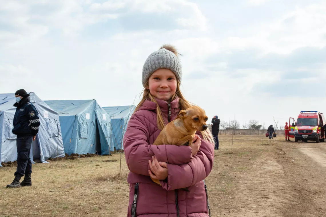 Moldova. Tatiana holds her dog at a temporary refugee centre.
