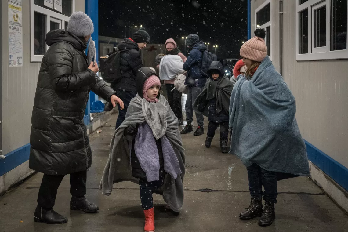 A family fleeing Ukraine enters Romania at the Isaccea border crossing in March 2022.