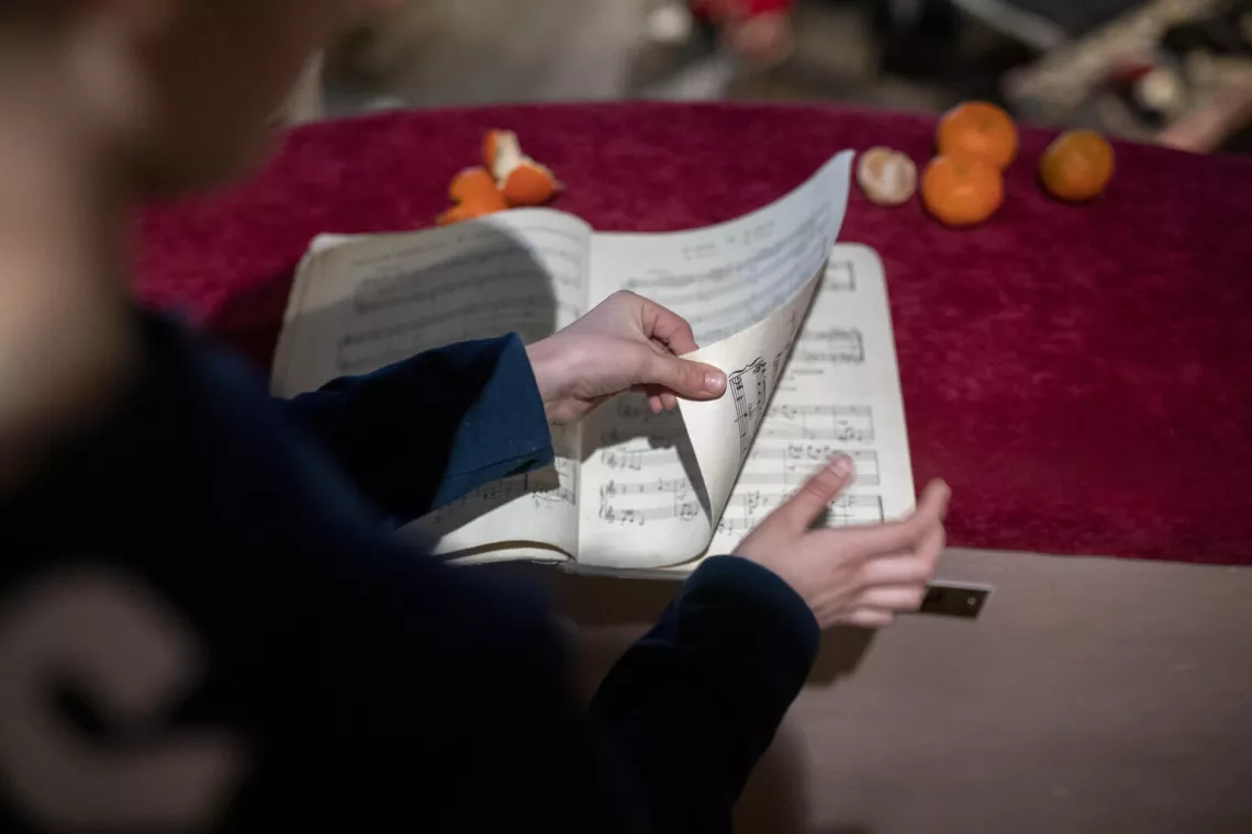 Ukraine. Maksym leafs through a book of piano scores in Lviv Academic Theatre in Ukraine.