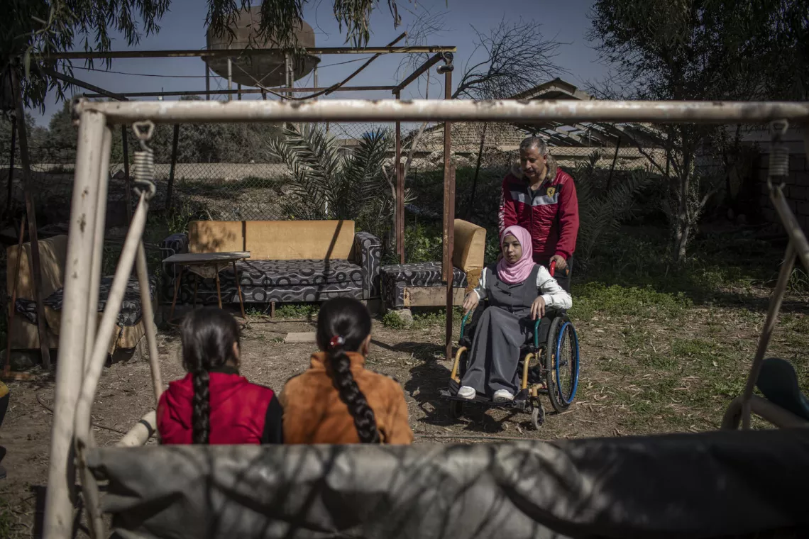 Dalia, en fauteuil roulant, passe du temps avec des amis dans son jardin.