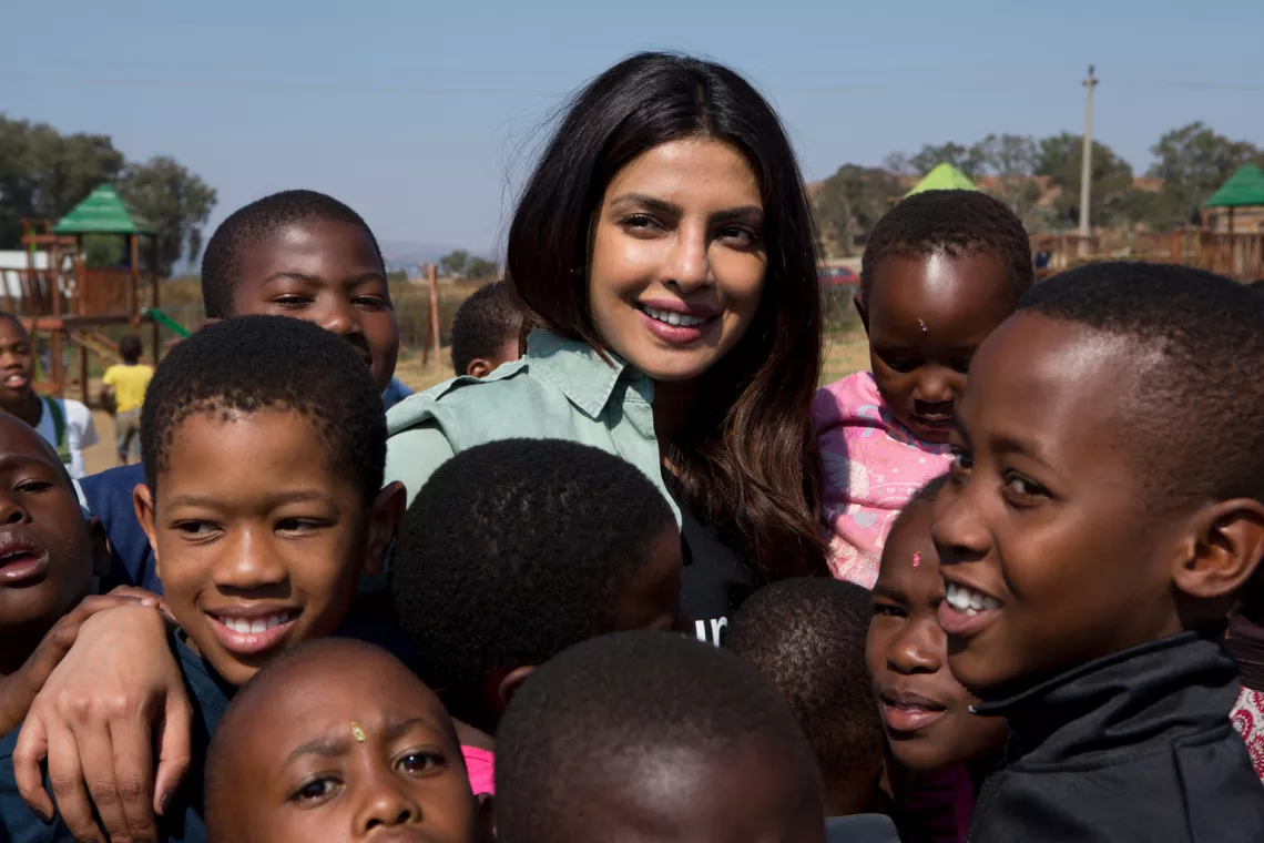 On 7 May 2017 in South Africa, UNICEF Goodwill Ambassador Priyanka Chopra smiles amid a group of children, at the Isibindi Safe Park in Soweto Township, in the city of Johannesburg.