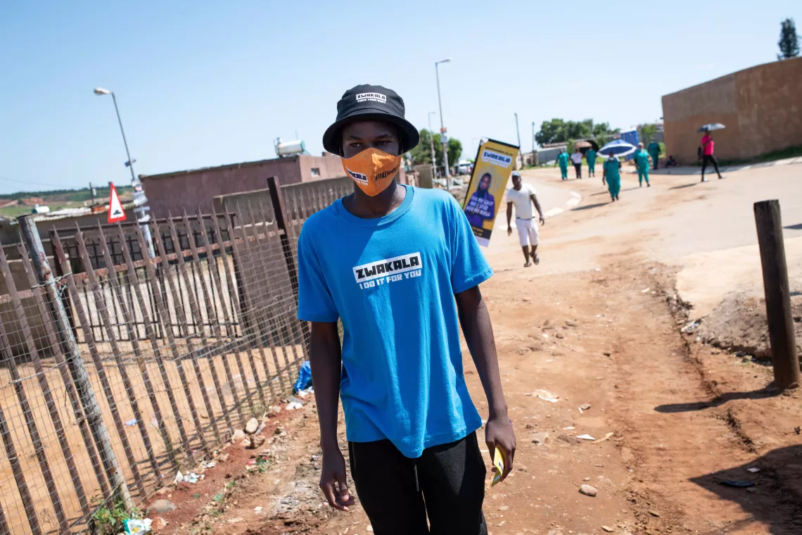 Bafana Chabalaba hands out COVID-19 vaccine information pamphlets to encourage members of the Ivory Park community to attend a clinic and receive their vaccines.  