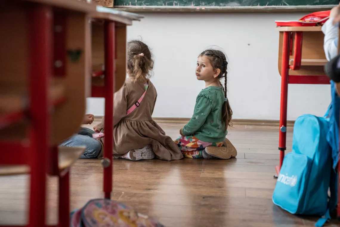 Romania. Two girls sit on the floor during a classroom activity.