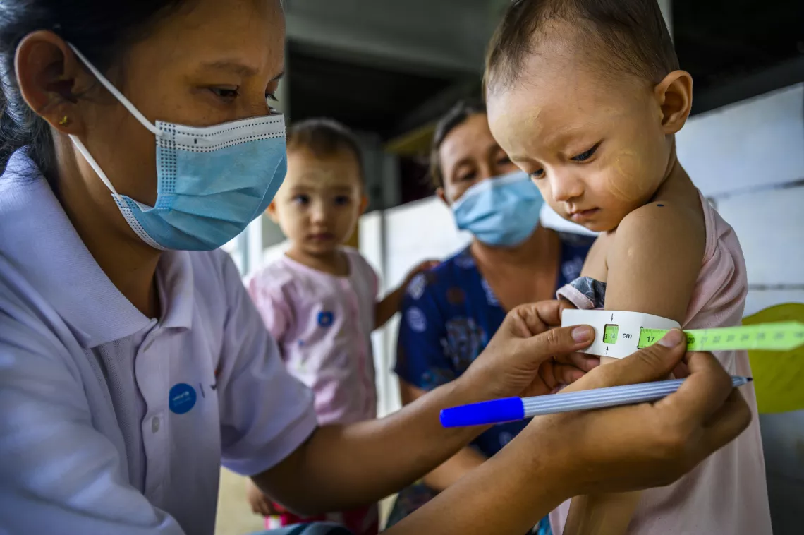 A nurse measuring the arm of a small child