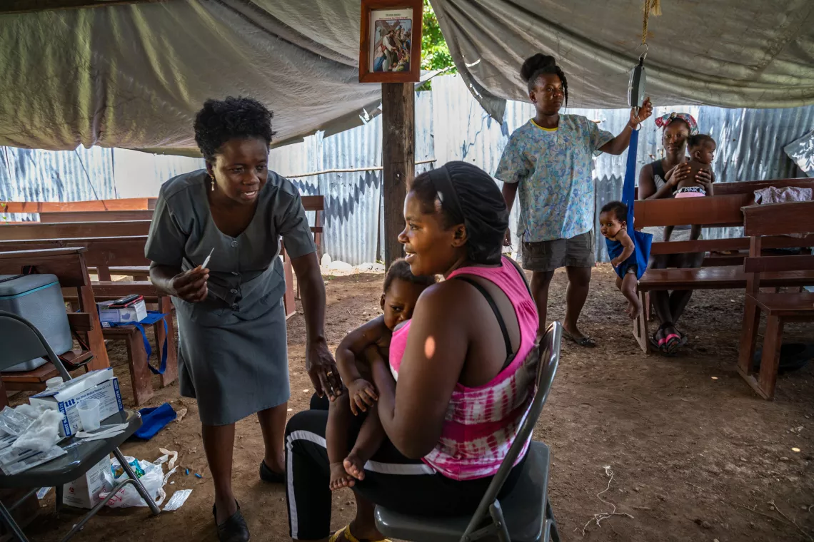 A nurse prepares to administer a vaccine at the outreach clinic. 