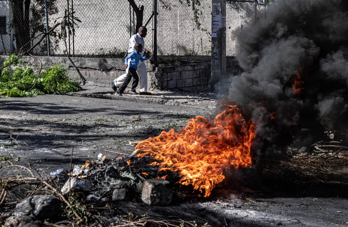 On 22 July 2022, a fire burns as Haitians protest the rising price of petrol and the state&rsquo;s inability to provide security in the capital by blockading large thoroughfares in the city centre in the Turgeau district in Port-au-Prince.