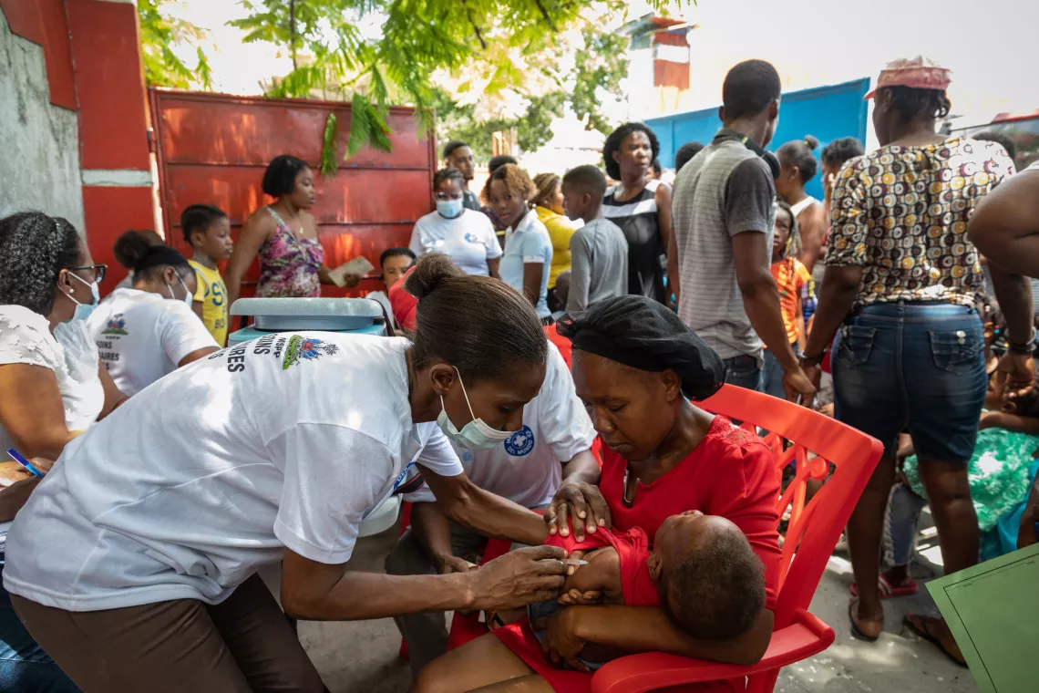 Nurse Chantale Chery administers a vaccine while Raynette Milhomme holds her child.