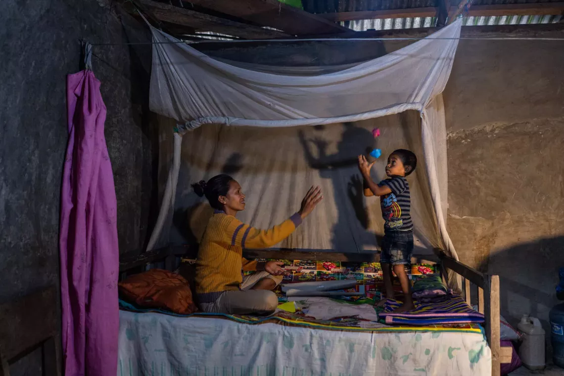 Marce plays with her four-year-old son, Alvius, in their home in Tunua Village, Indonesia. 