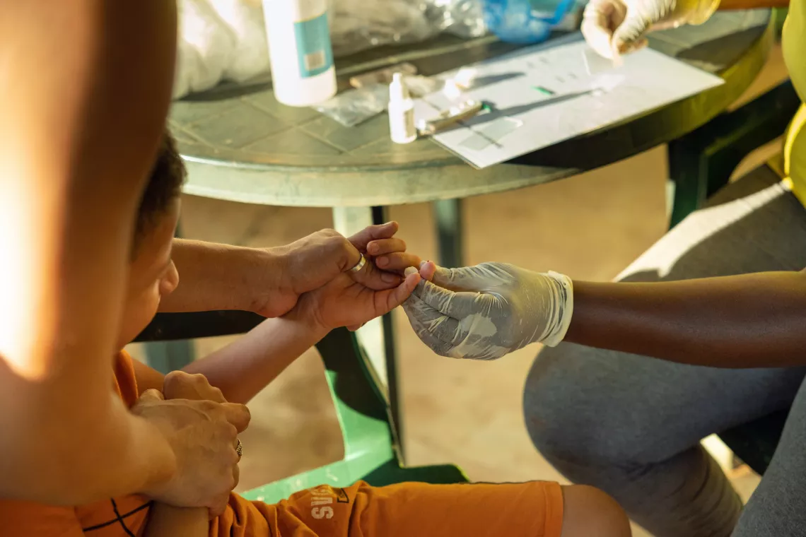 Hortance Nelson (Microscopist Superviser) doing a traditional Malaria test and Rapid Malaria test with Valeria Ferreira da Silva (Sex club owner) and Arthur Vinicius Ferreira da Silva (her son age 8) Vila Brazil Suriname