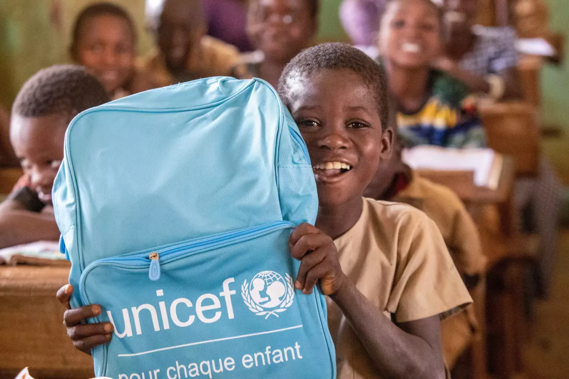 C&ocirc;te d'Ivoire. A child holds up a UNICEF backpack in Gu&eacute;gouin in western C&ocirc;te d'Ivoire.