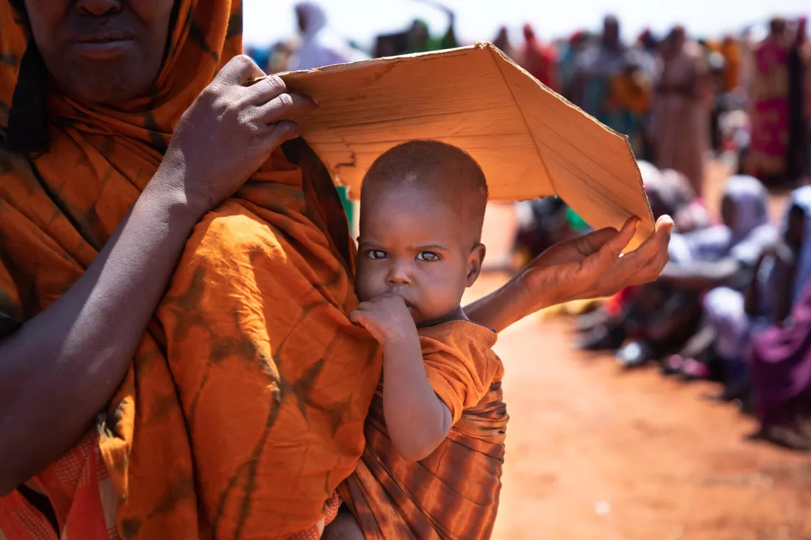 Una madre protege a su hijo del sol con un trozo de cart&oacute;n en Hegalle, en la regi&oacute;n somal&iacute; de Etiop&iacute;a.