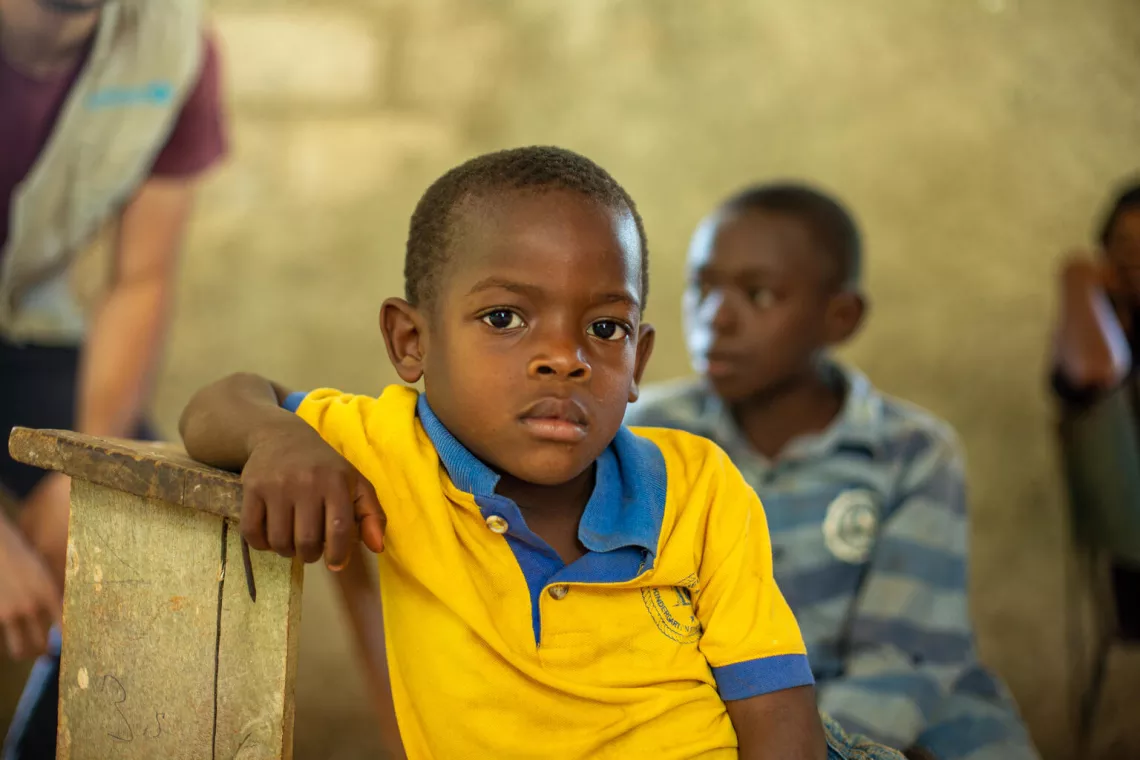 Un ni&ntilde;o sentado durante una reuni&oacute;n con beneficiarios de un programa de agua limpia dirigido por UNICEF en la ciudad de J&eacute;r&eacute;mie, en Hait&iacute;.
