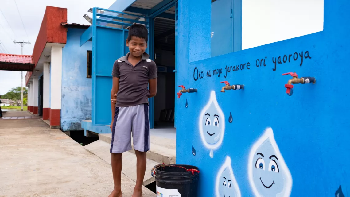 A boy, 10, collects safe water at the UNICEF-installed solar-powered water treatment plant in Venezuela