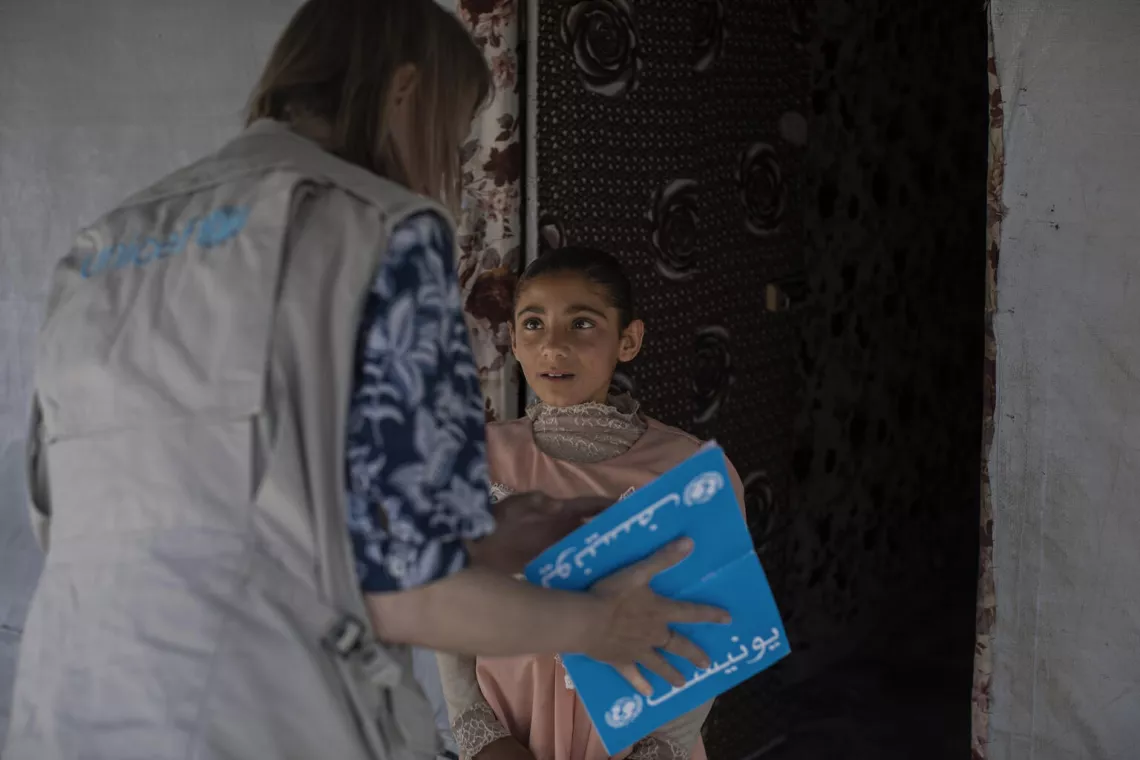 Iraq. A member of a UNICEF team meets a girl at her temporary home located at the Hassansham camp for internally displaced persons. 
