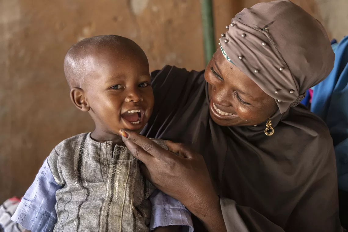 A grandmother smiles at her grandson.