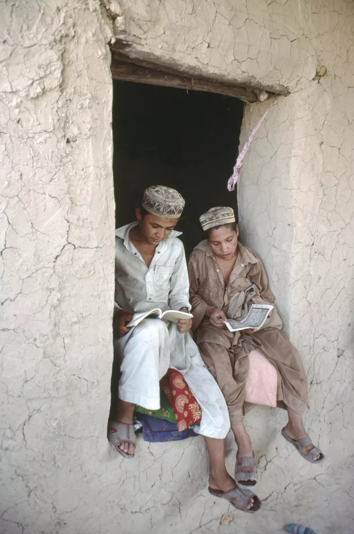 Two boys reading in a temporary school in Pakistan.