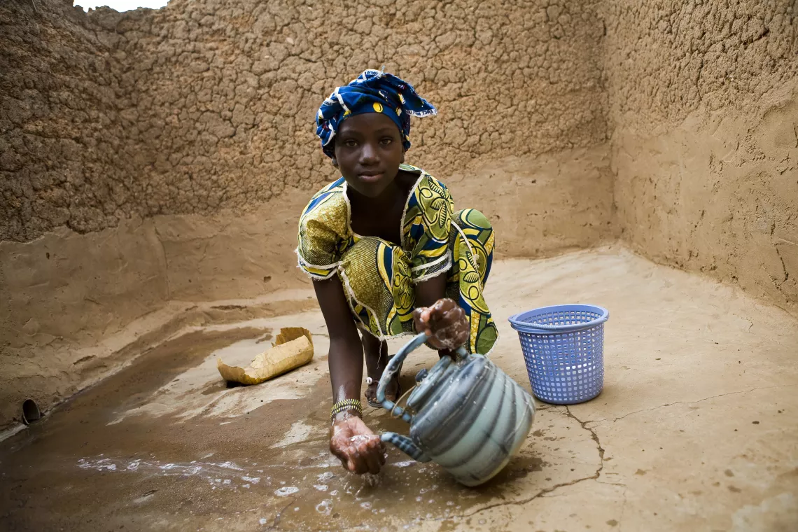 Une jeune fille montre comment elle se lave les mains dans des latrines &agrave; fosse, dans le village de Sirakoro. 