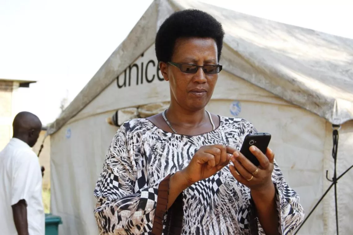 A health worker checks cholera alerts from RapidPro on a mobile phone.