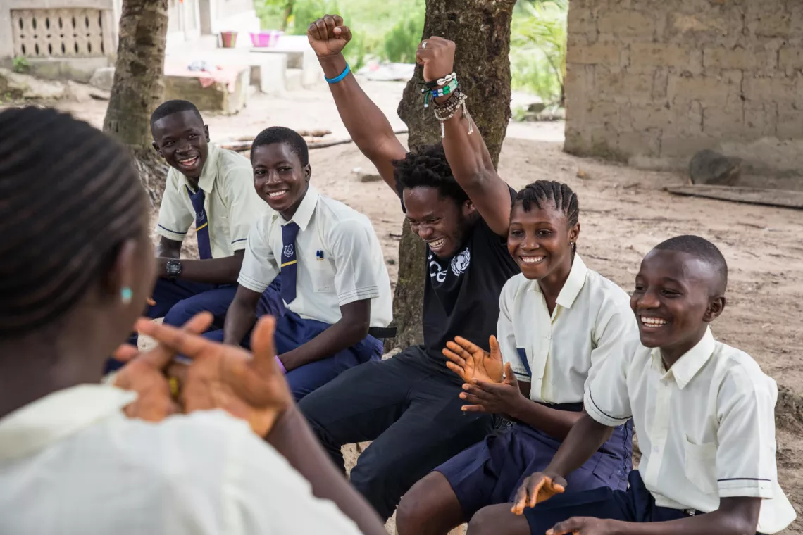 Ishmael in Kabumbeh village, Bimbali district, in Sierra Leone, talks with students learning life skills to support the healthy development of young people.