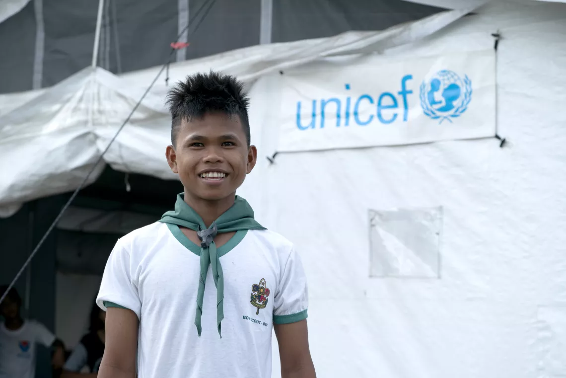 Philippines. A boy stands outside a prototype High Performance Tent.