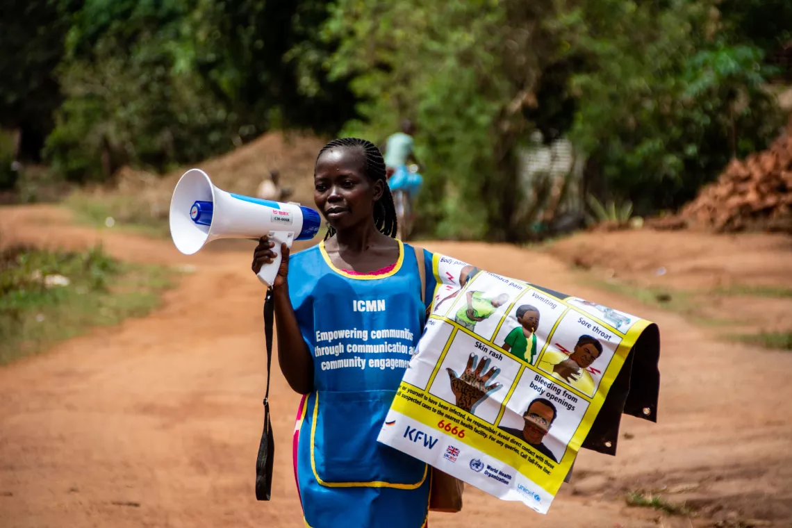 Victoria Hayat announces COVID-19 information through a megaphone in Yambio, South Sudan.
