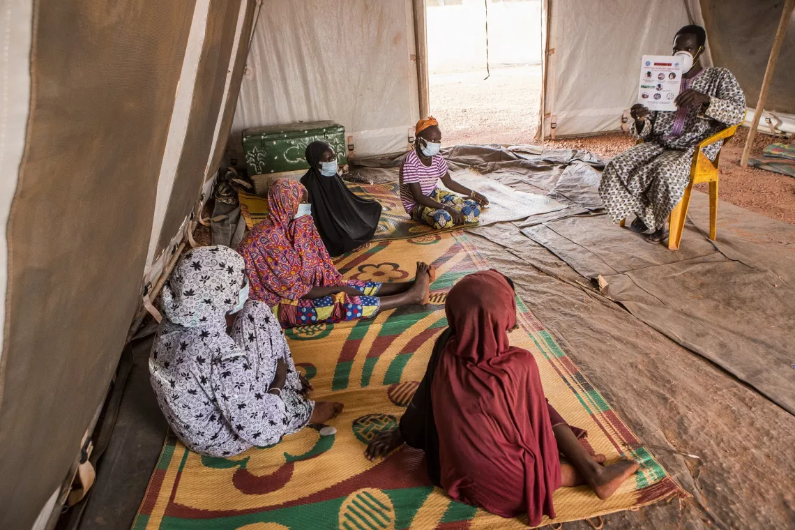 Mali. Residents in an IDP camp listen to a session discussing COVID-19 prevention.