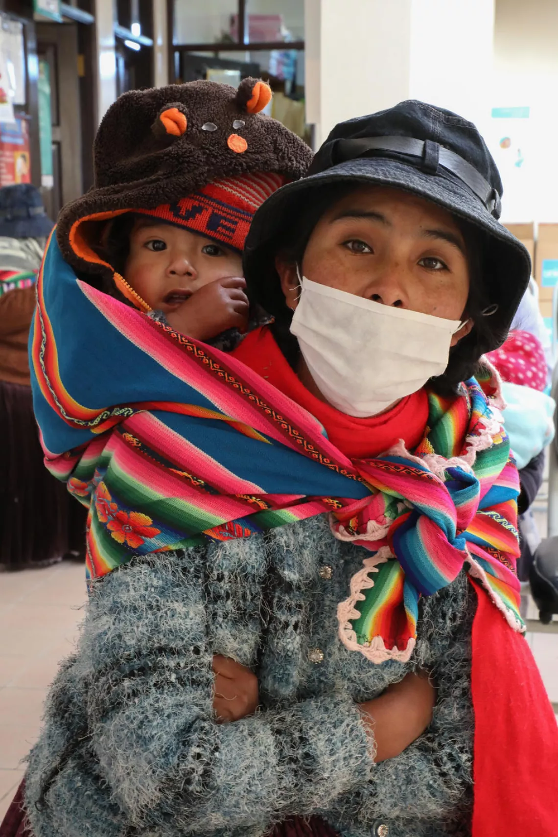 Jonatan and his mother wait to be seen at the Los Pinos health centre in El Alto, Bolivia, on 26 May 2020. 