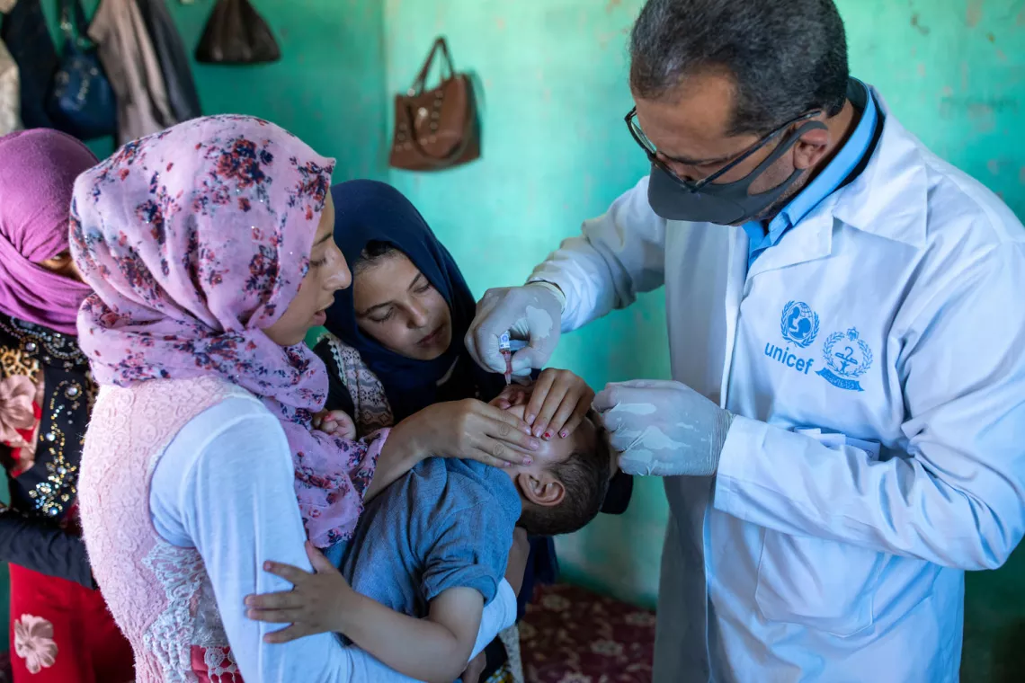 A boy receives a vaccine from a health worker during a joint UNICEF-WHO vaccination campaign in an informal tented settlement in Zarqa governorate, Jordan, on 23 June 2020.
