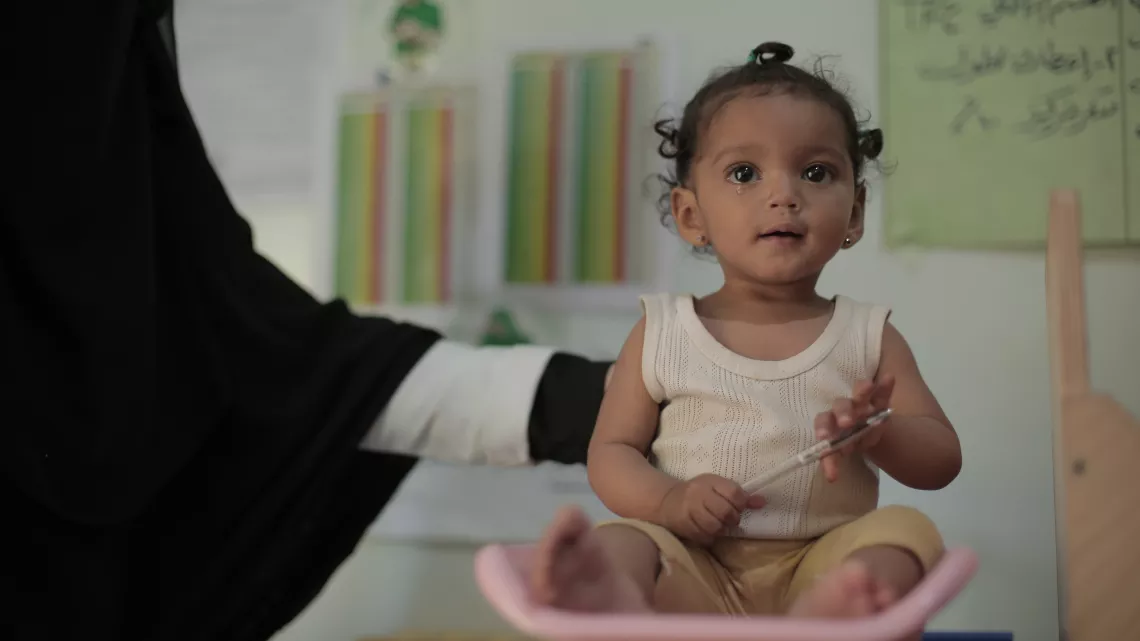 Yemen. A child is weighed at a health centre.
