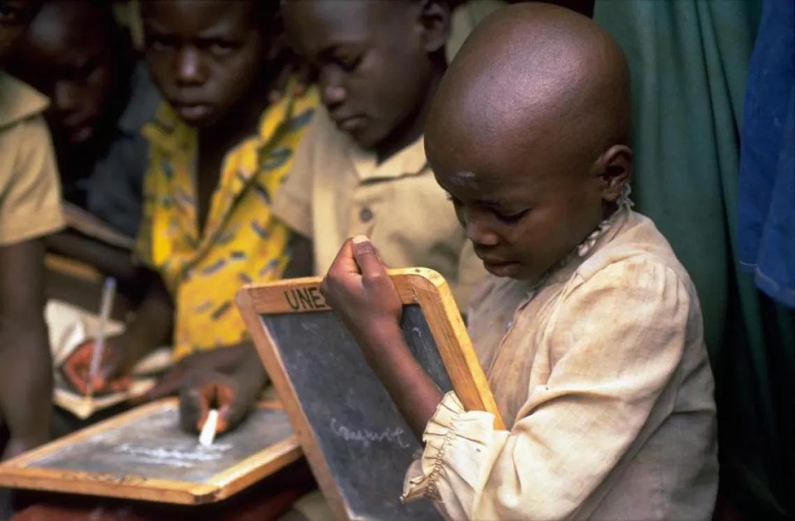 Children write on chalkboards