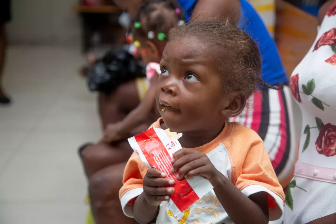 A child eats a sachet of ready-to-use therapeutic food (RUTF)