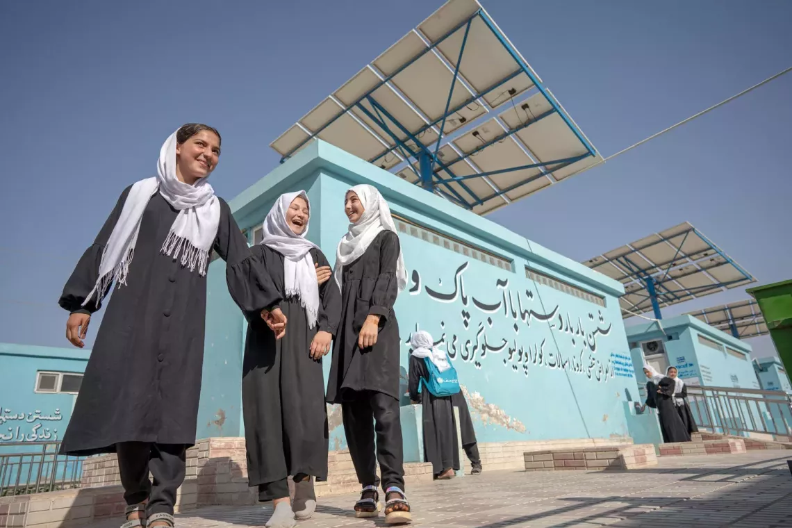 Girls stand outside the new solar-powered latrines at their school in Afghanistan.