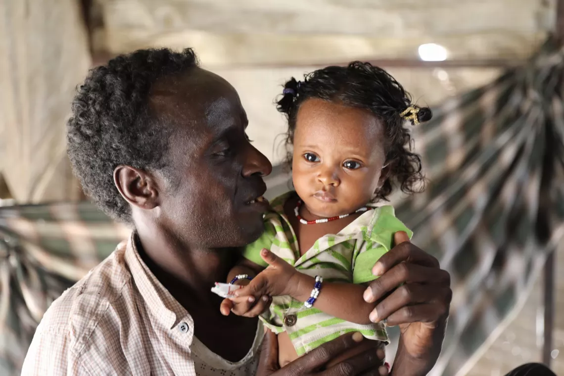 Medina with her father in front of their home.