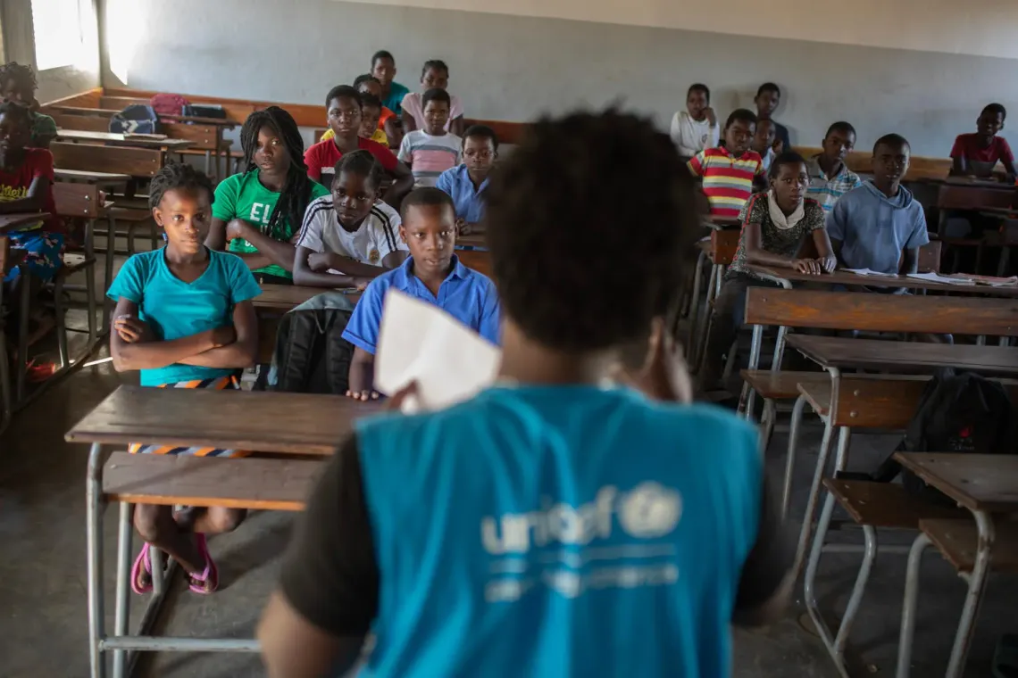 Mozambique. A UNICEF programme manager speaks with students about climate change at a school in Buzi District, Sofala Province.