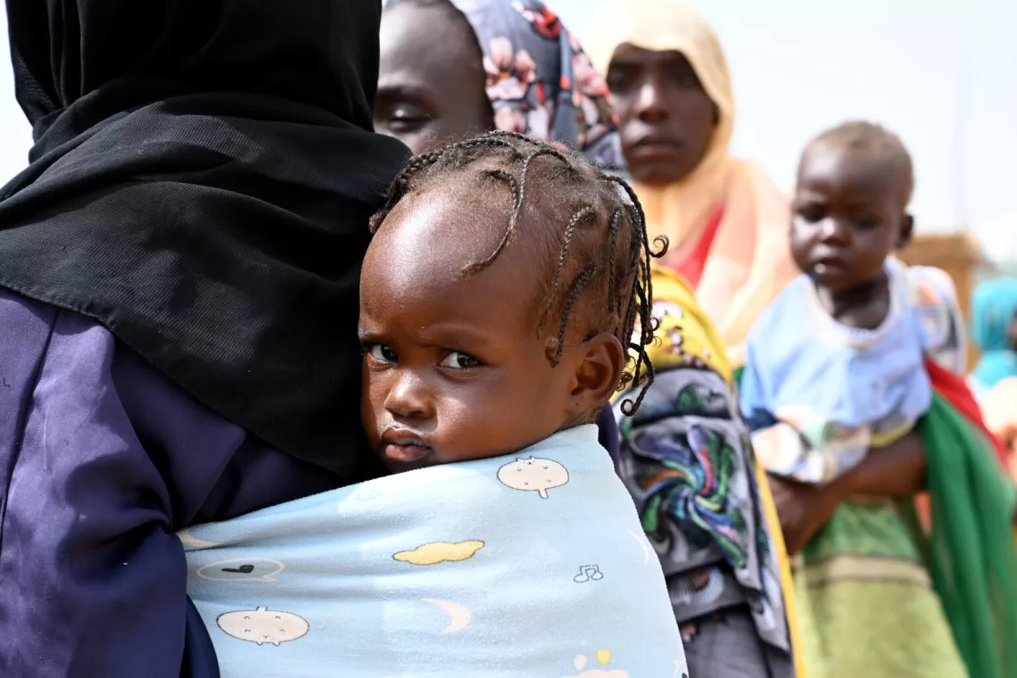 Una madre con su beb&eacute; a la espalda en un campamento de refugiados del este de Chad, cerca de la frontera con Sud&aacute;n.
