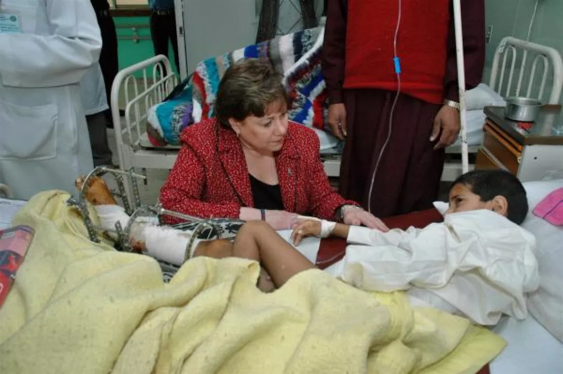 Ann M. Veneman, UNICEF Executive Director, sits at the bedside of an earthquake victim. Pakistan, 2005.