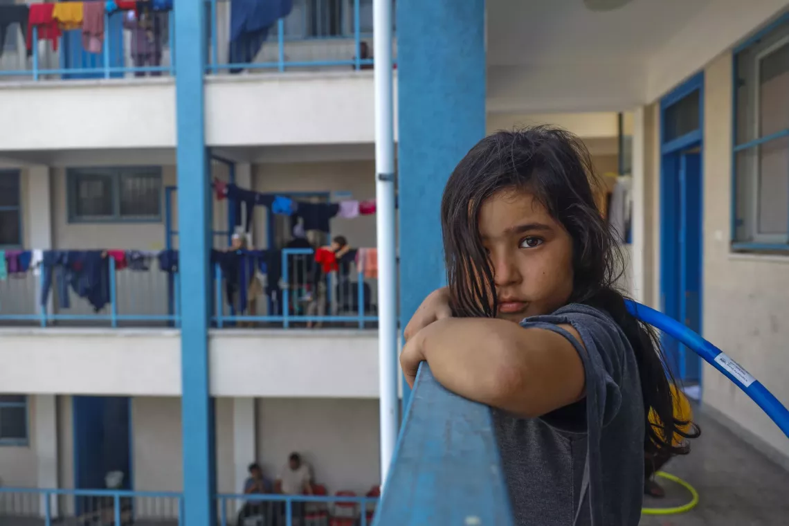 Jannat, an 8-year-old girl, watching other children play in the UNRWA school playground. 