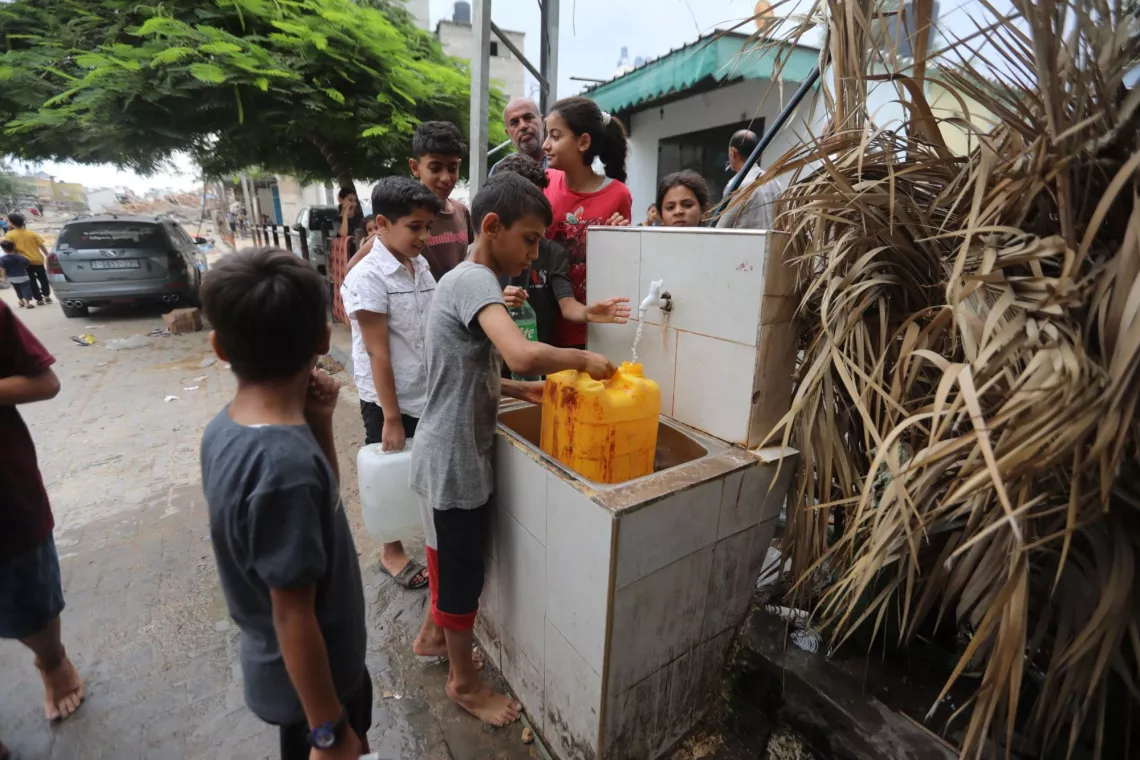 Oct 8, 2023: Palestinian children fill drinking water from public areas amid an escalating conflict.